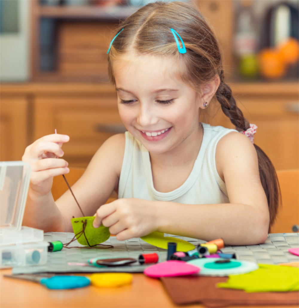 Child concentrating on a Montessori-based sewing project